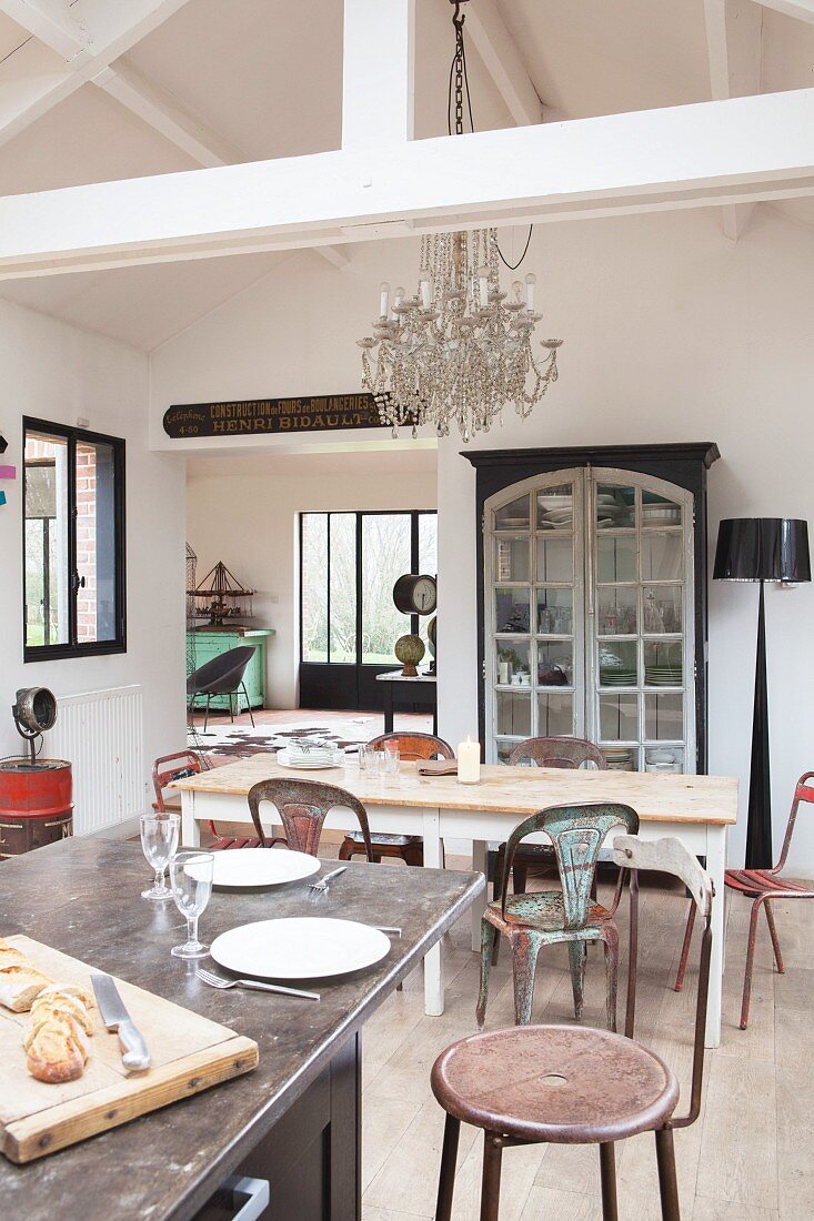 View across island kitchen counter to dining table and metal chairs