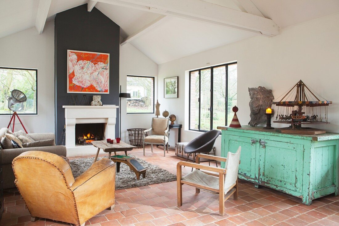 Various vintage chairs and terracotta floor in living room
