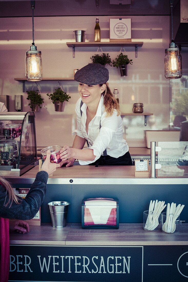 Junge Frau verkauft Snack im Food Truck