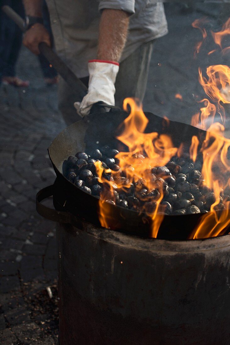 Chestnuts being fried in a large pan
