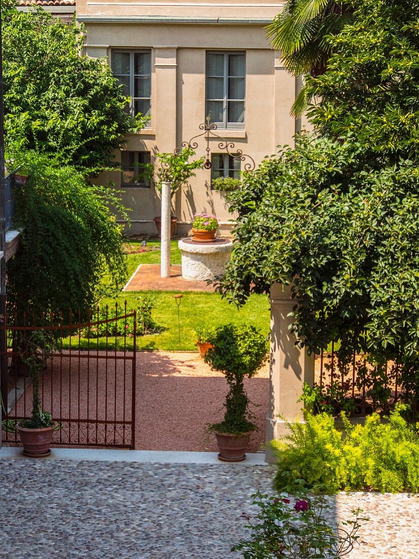 Open gate leading into Mediterranean courtyard garden