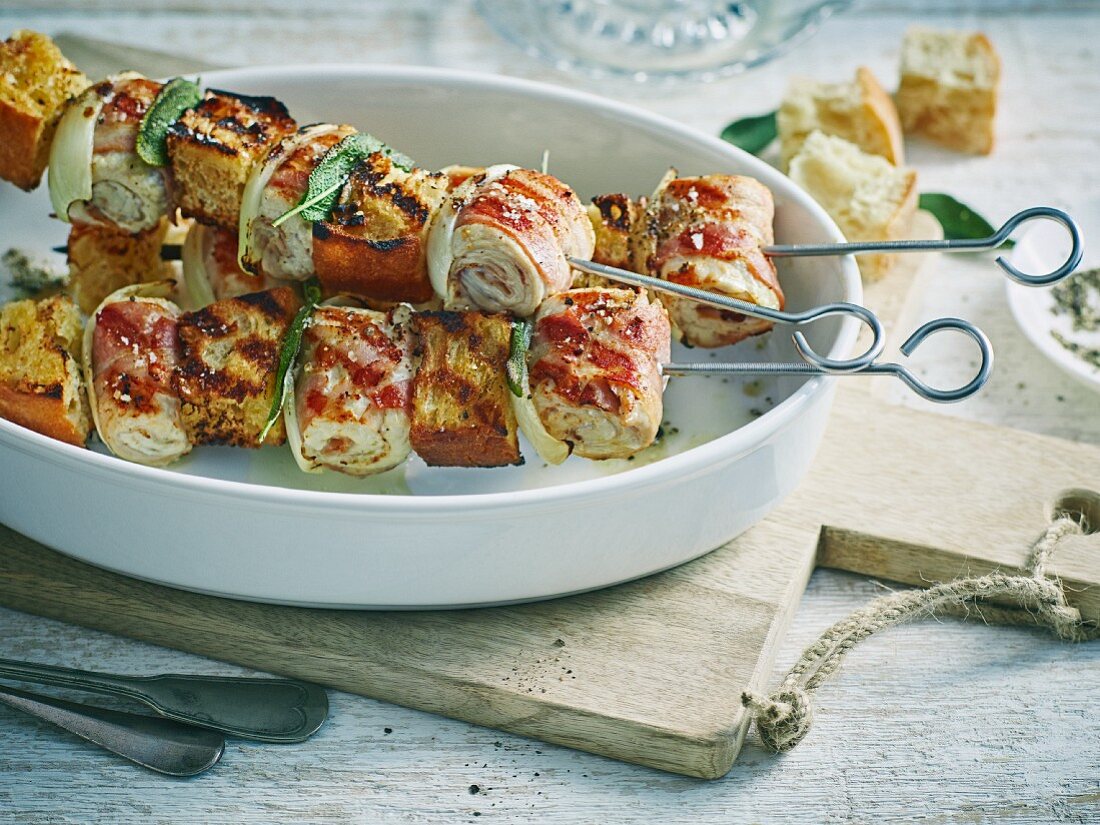 Grilled turkey and bacon rolls with white bread on skewers