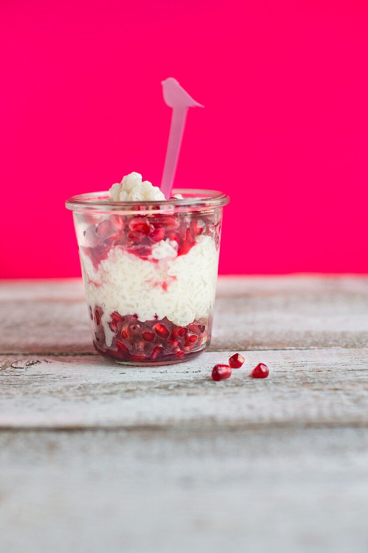 Coconut rice pudding with pomegranate seeds in a glass