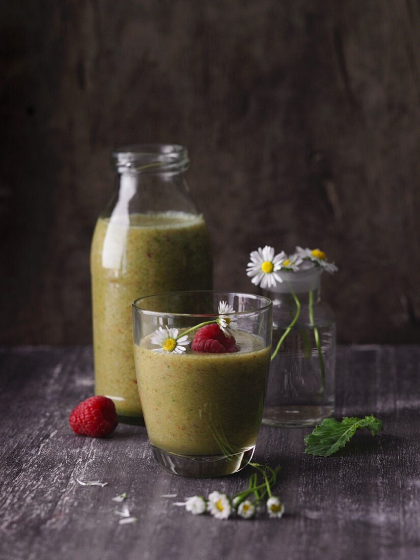 A raspberry and banana smoothies with leaves and daisies