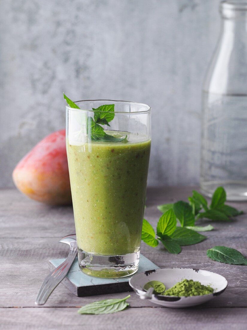 A green matcha and peppermint smoothie with dates, figs and mango