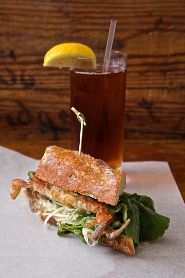 A soft shell crab sandwich served with iced tea