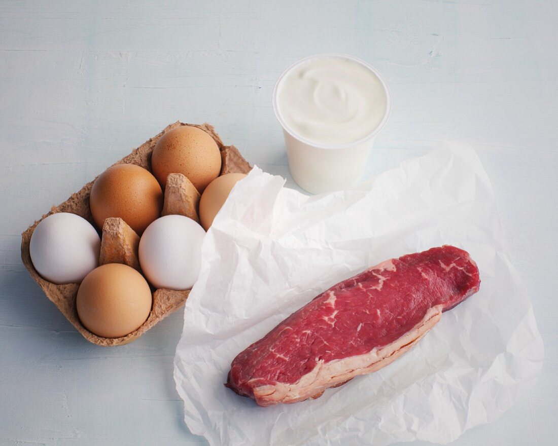 A raw steak, eggs and yoghurt