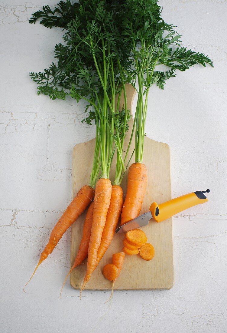 Carrots and a knife on a chopping board