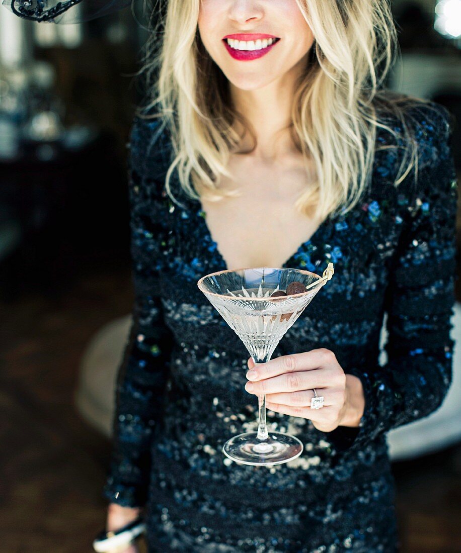 Frau hält ein Glas Martini