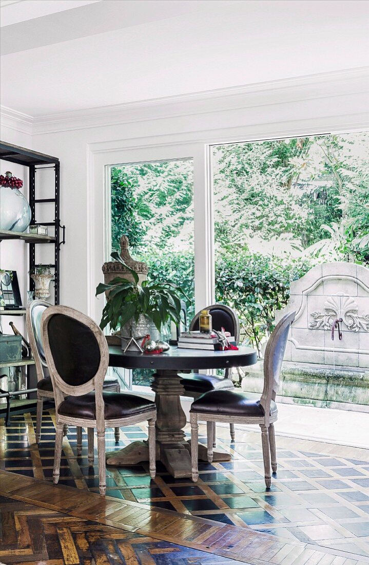 Dining area with vintage Rococo style chairs in front of window, antique mosaic parquet