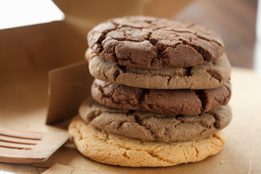 A stack of assorted chocolate chip cookies next to a box