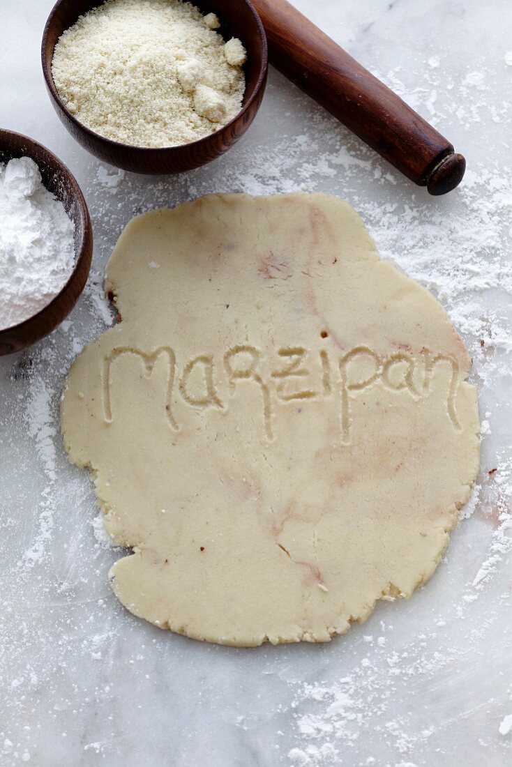 Ausgerolltes, selbstgemachtes Marzipan mit eingraviertem Wort auf Marmorplatte