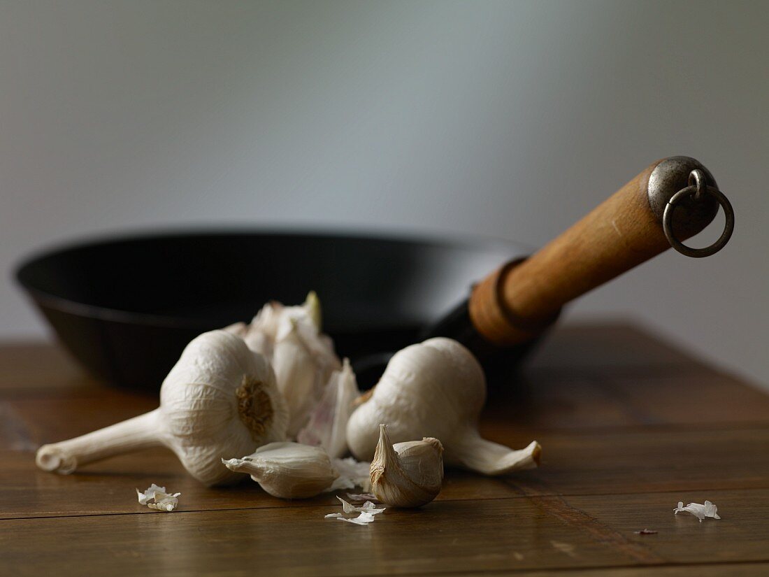 Garlic and a pan on a wooden table