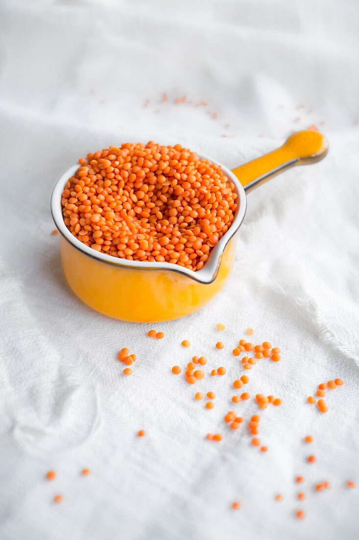 Organic red lentils in a 1970s saucepan on a linen cloth