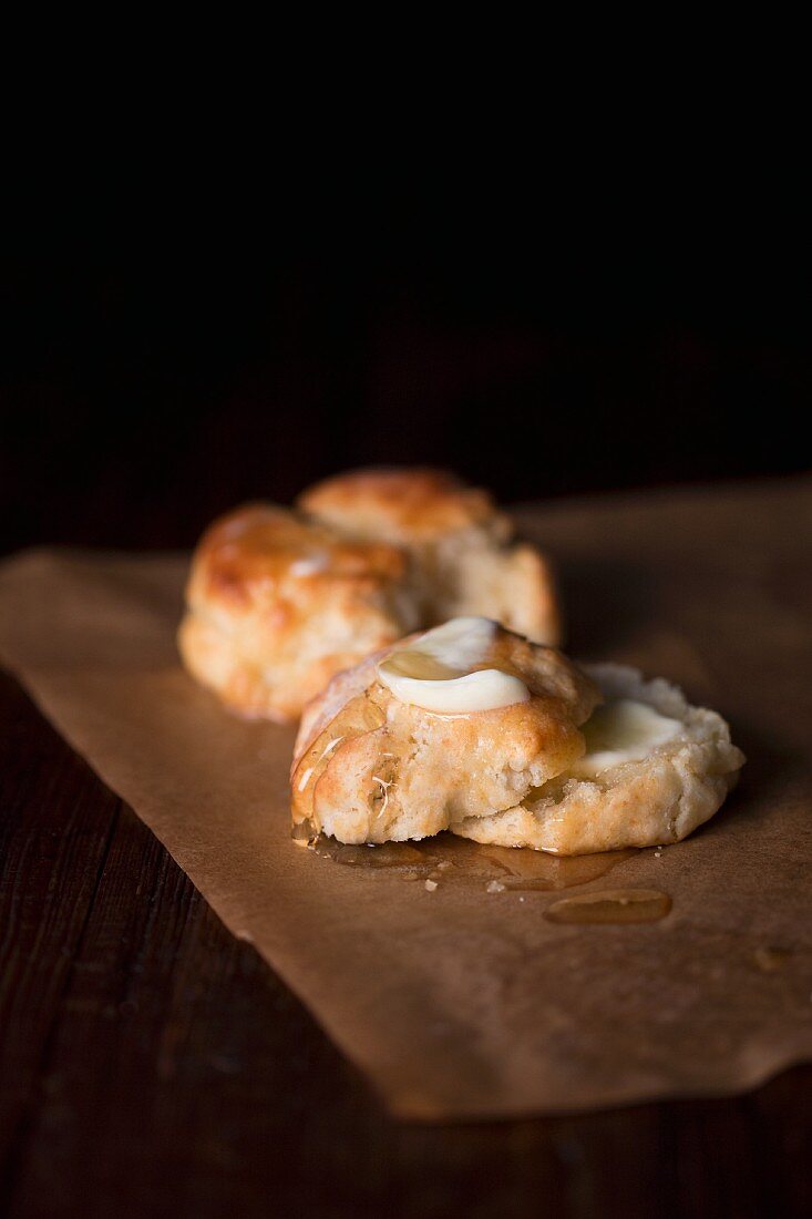 An American biscuit with butter on a piece of baking paper