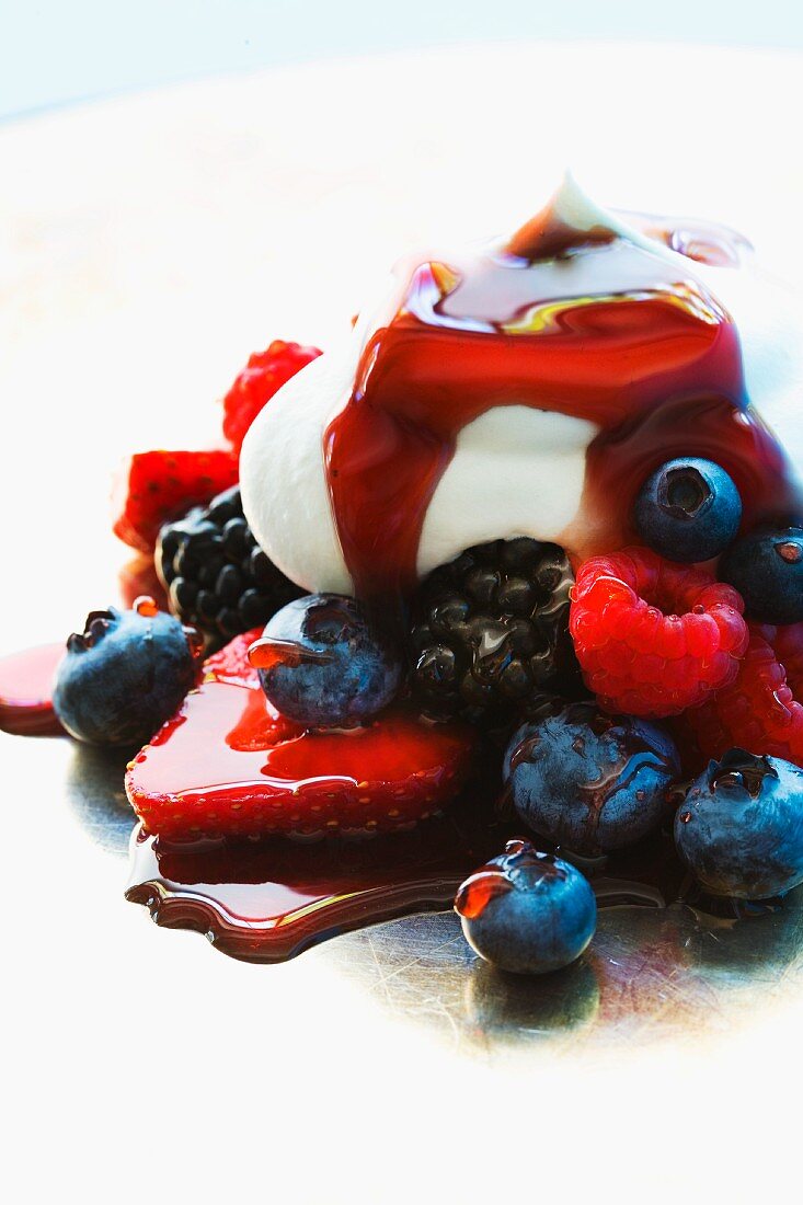Fresh berries with cream and syrup (close-up)
