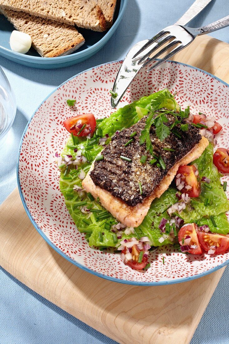 Gegrillter Lachs auf Kohlgemüse mit Zwiebeln und Tomaten