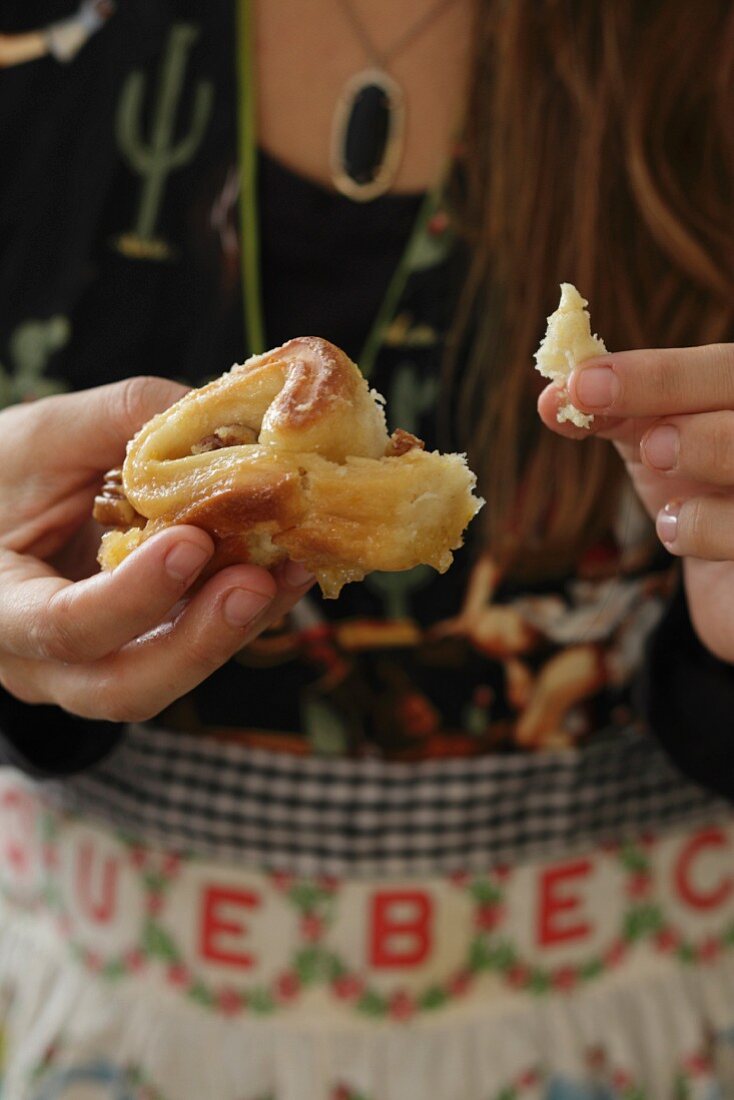 Hands holding sticky orange cake