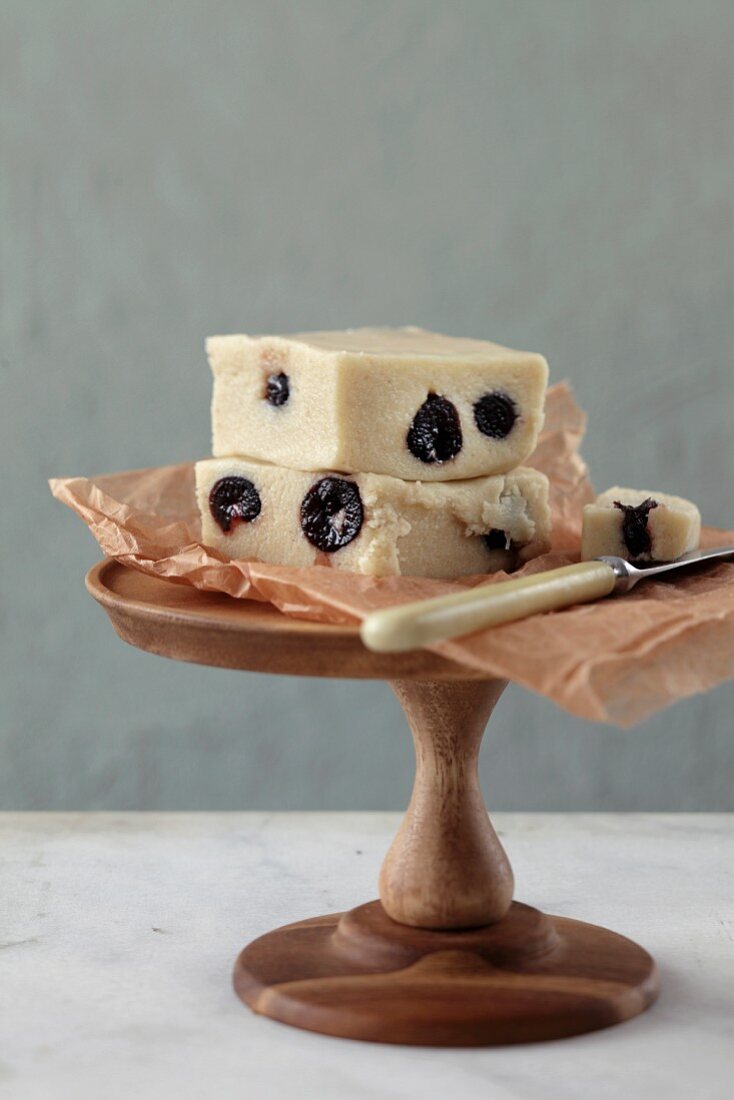 Homemade marzipan with amarena cherries on a wooden stand