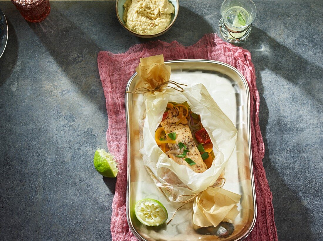 A salmon parcel with vegetables and hummus