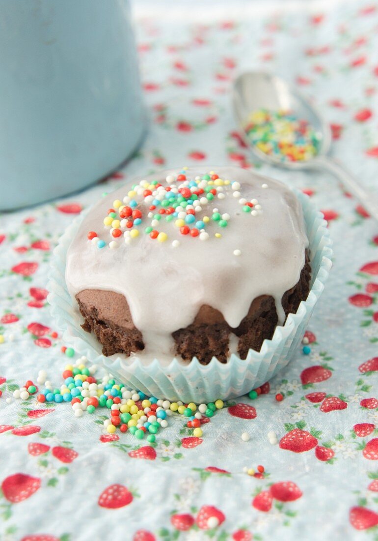 Schokoladenmuffin mit Zuckerguss und Zuckerstreuseln