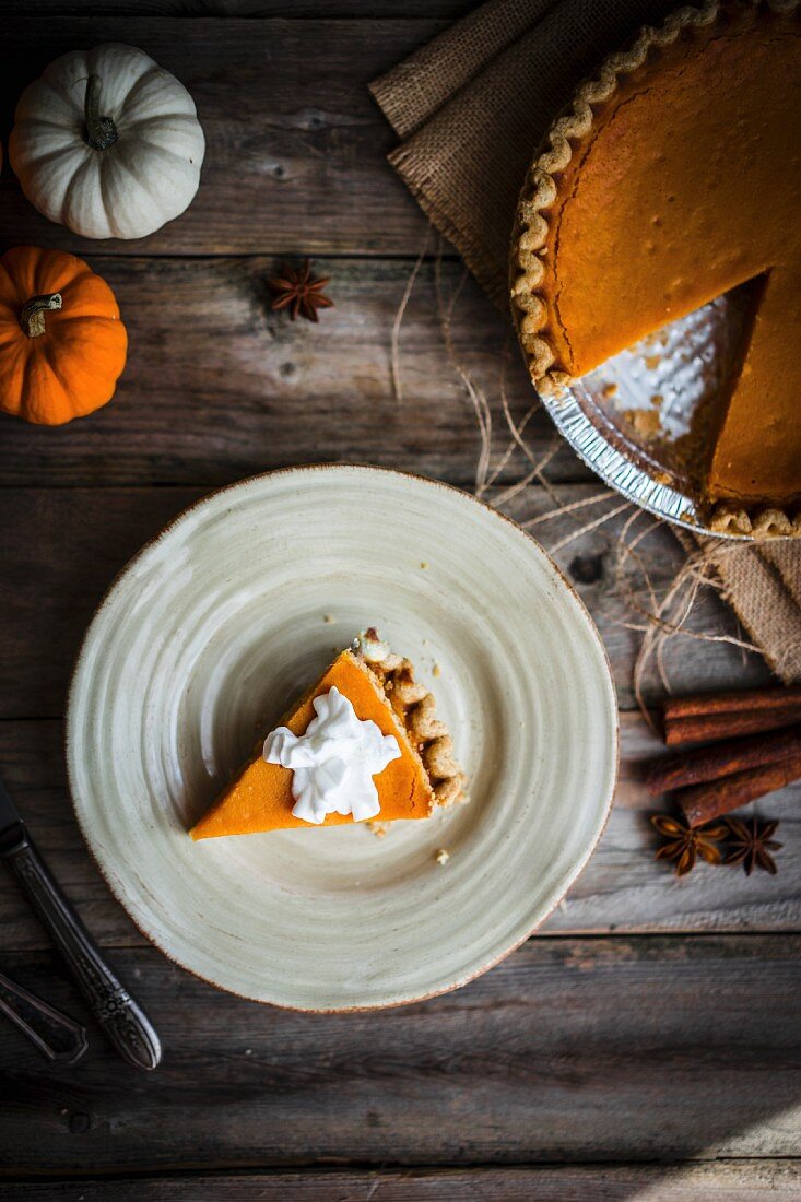 Pumpkin pie on a rustic wooden surface (seen from above)