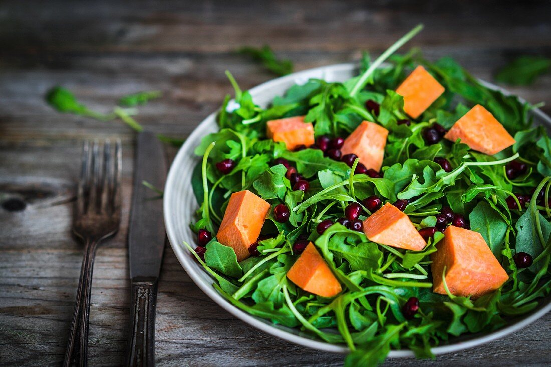 Fresh rocket and spinach salad with pumpkin and pomegranate seeds