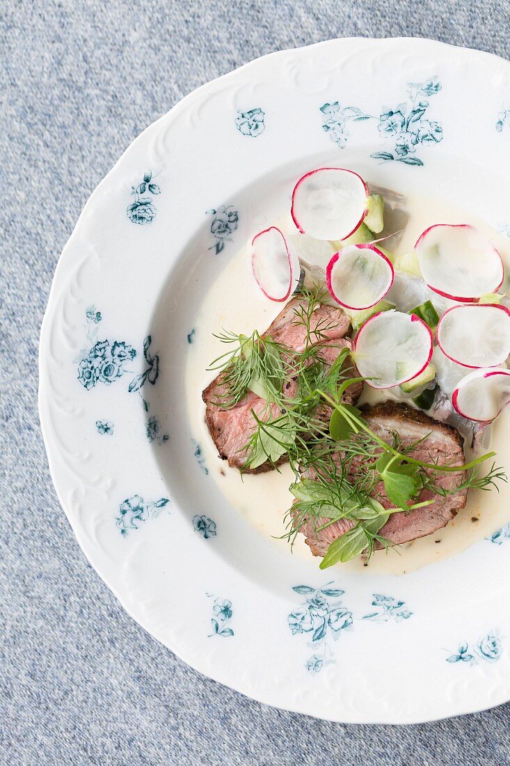 Fried duck breast with fresh herbs and radishes