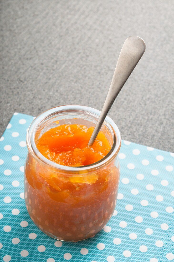Kürbis-Orangen-Marmelade im Glas mit Löffel
