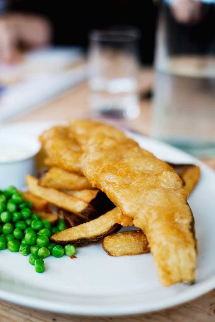 Fisch und Chips mit Erbsen in einem englischen Restaurant