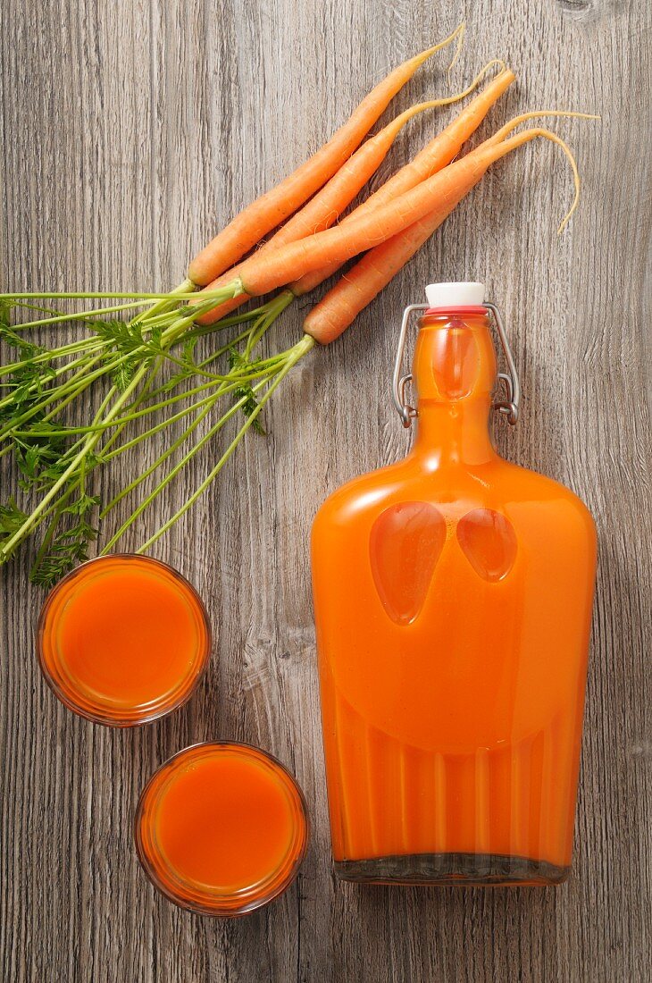 Karottensaft in Gläsern und Bügelflasche (Aufsicht)
