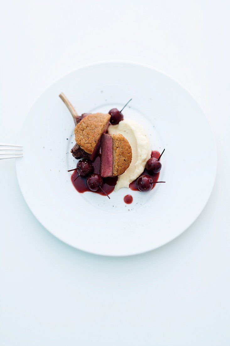 A venison chop with a chestnut crust on a bed of mashed celeriac and Port wine cherries