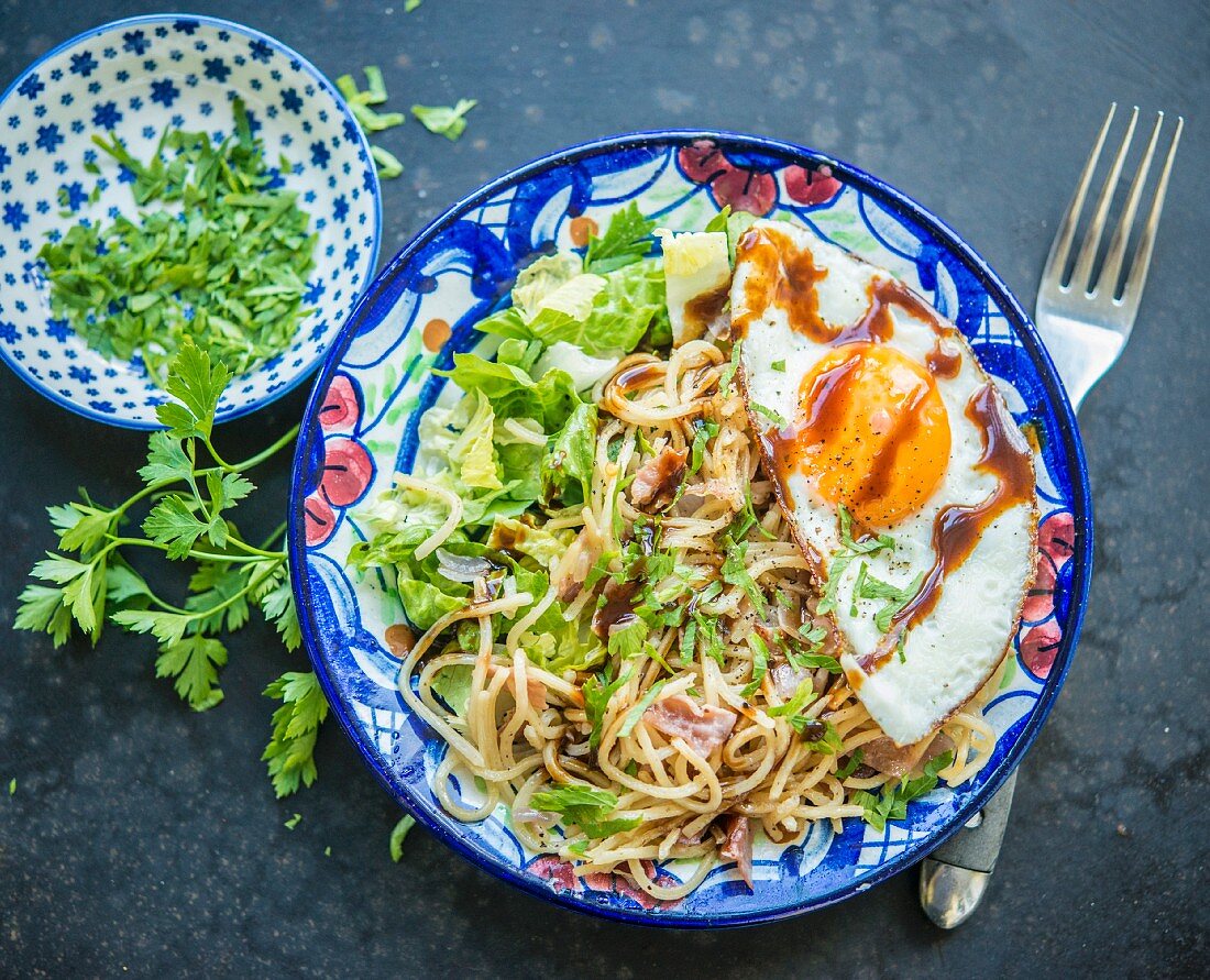 Fried noodles with salad and a fried egg (Asia)