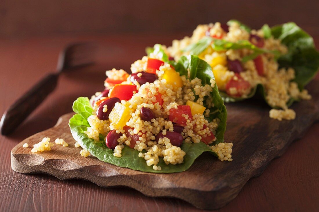 Quinoa salad with beans, peppers and tomatoes on lettuce leaves