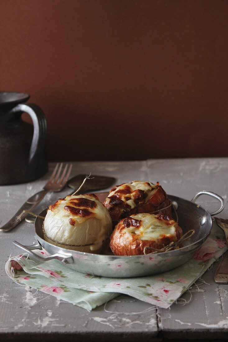 Stuffed onions with cheese in a pan
