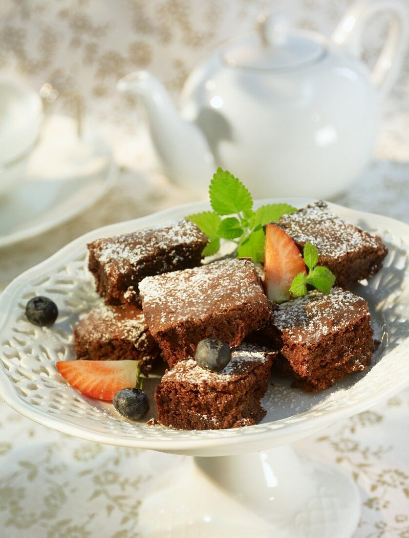 Pieces of chocolate cake with icing sugar and berries