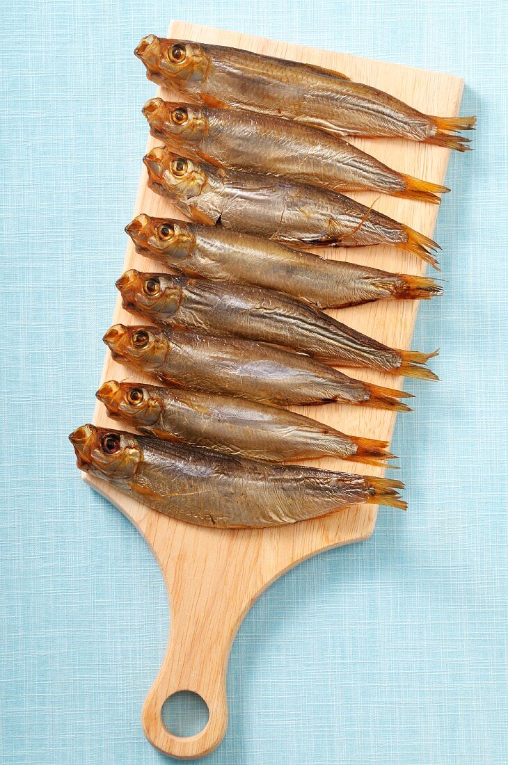 Smoked sprats on a wooden board