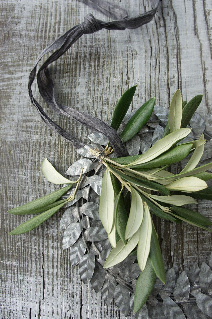 Wreath of silver-grey metal leaves decorated with olive sprig