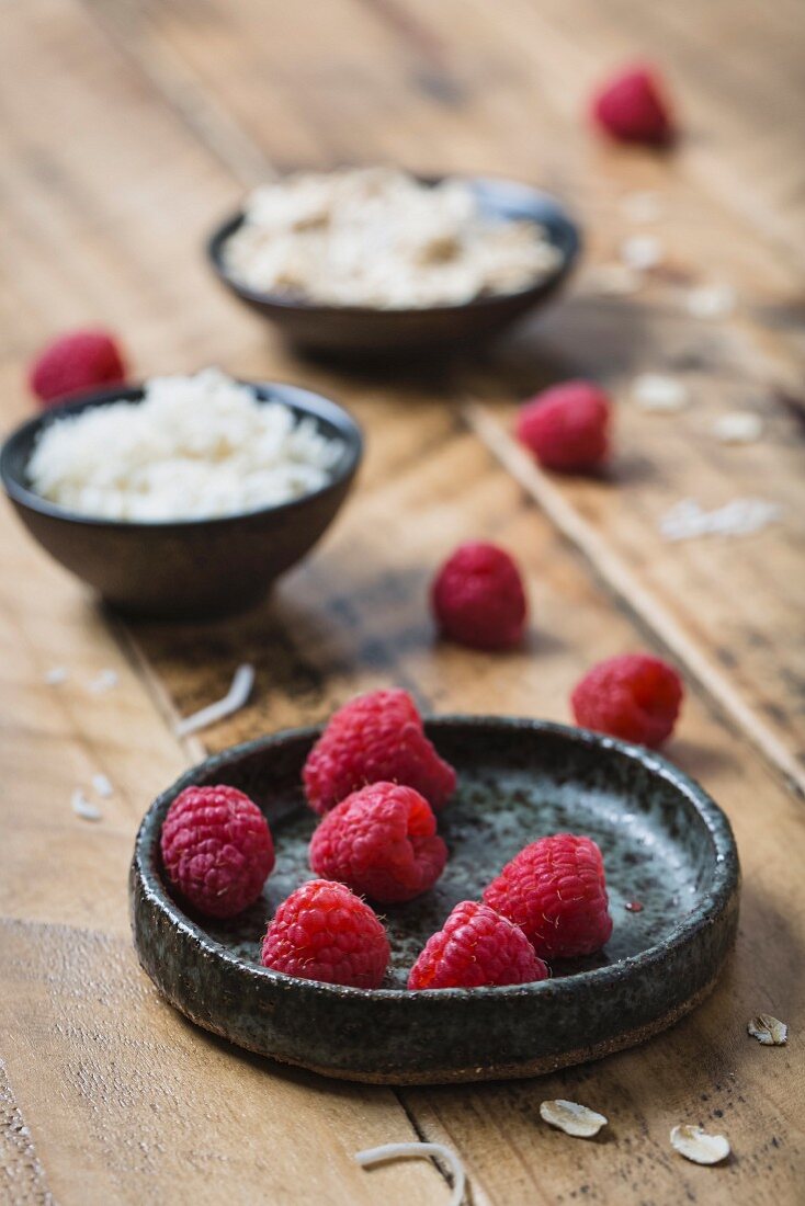 Fresh raspberries with oats and coconut on a wooden surface