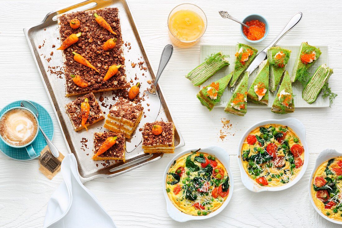 A brunch buffet with carrot cake, green pancake cake and pea frittata in pans