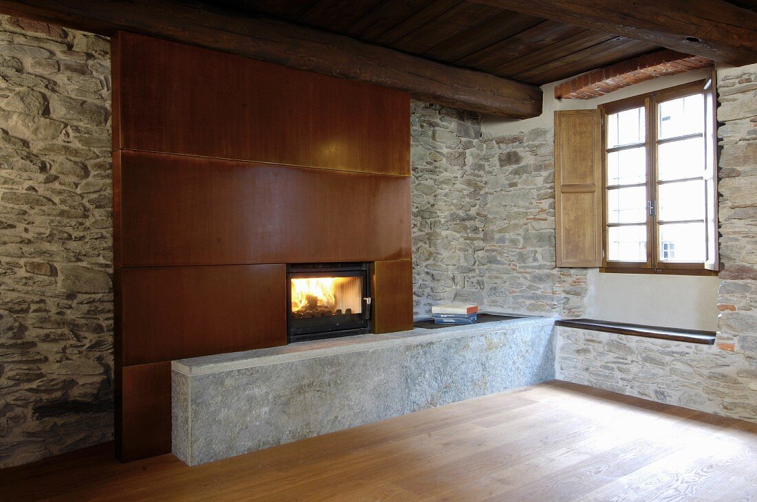Fireplace with metal chimney break in rustic stone wall