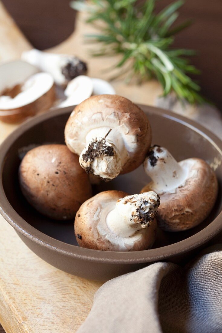 Button mushrooms in a brown bowl