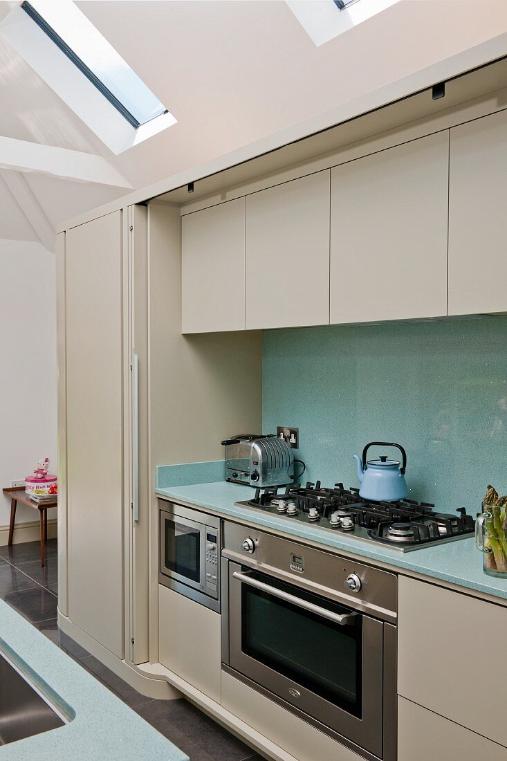 Fitted appliances in modern kitchen counter with sliding door