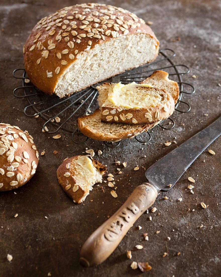 Sliced oat bread spread with butter