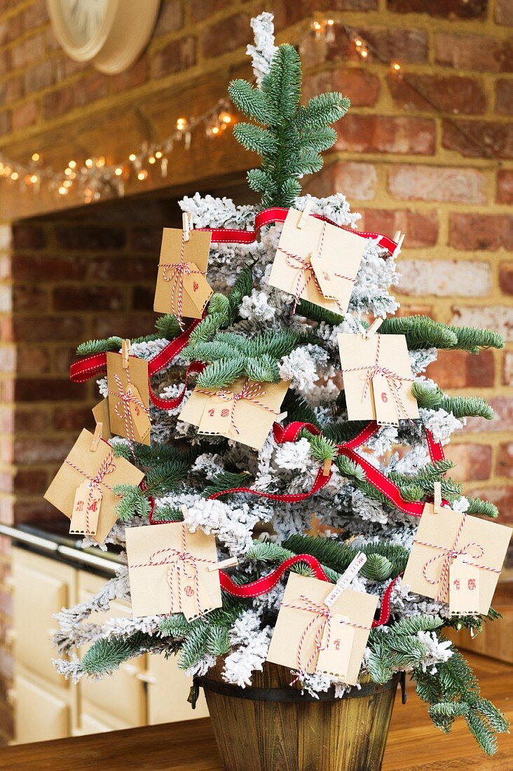 Christmas tree decorated with DIY Advent calender made from envelopes tied with ribbons