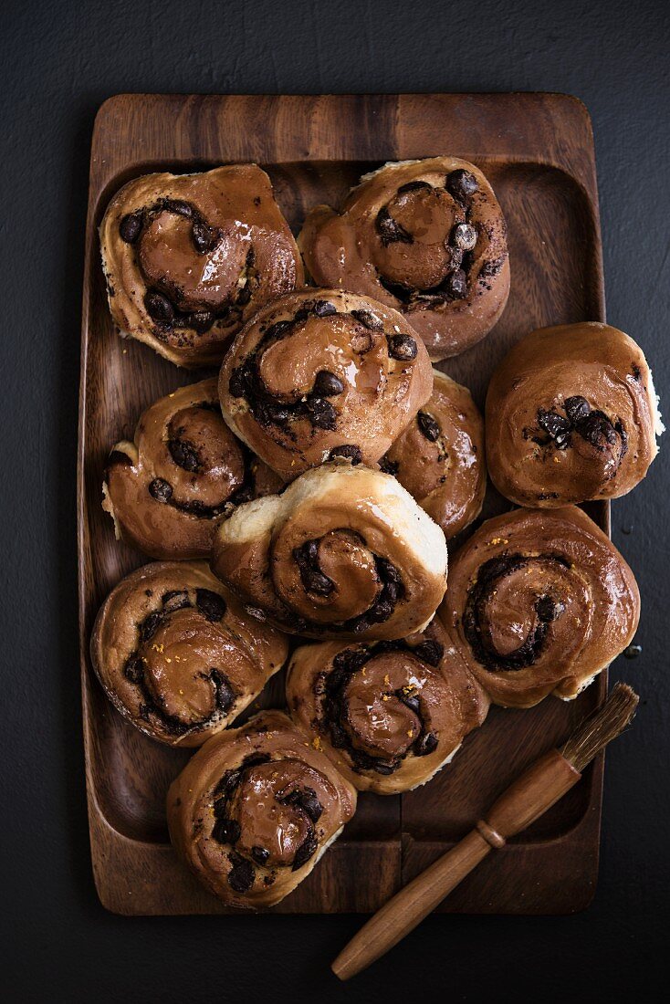 Chocolate buns on a wooden plate (seen from above)