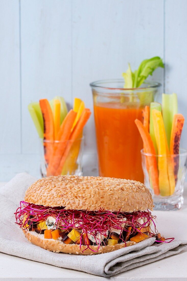 A bagel with carrots, blue cheese and beetroot sprouts