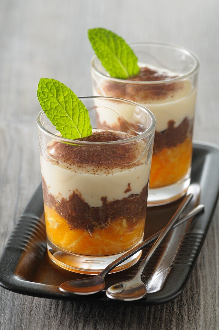 Tiramisu with oranges and cocoa in dessert glasses