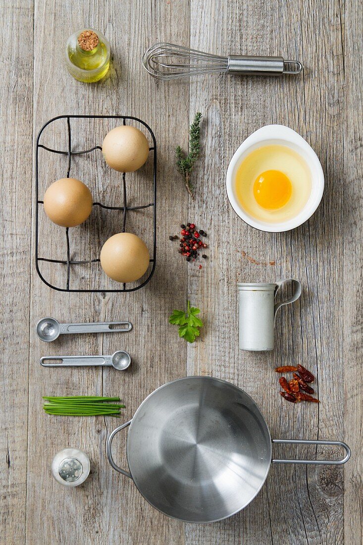 An arrangement of kitchen utensils and ingredients for egg dishes (seen from above)