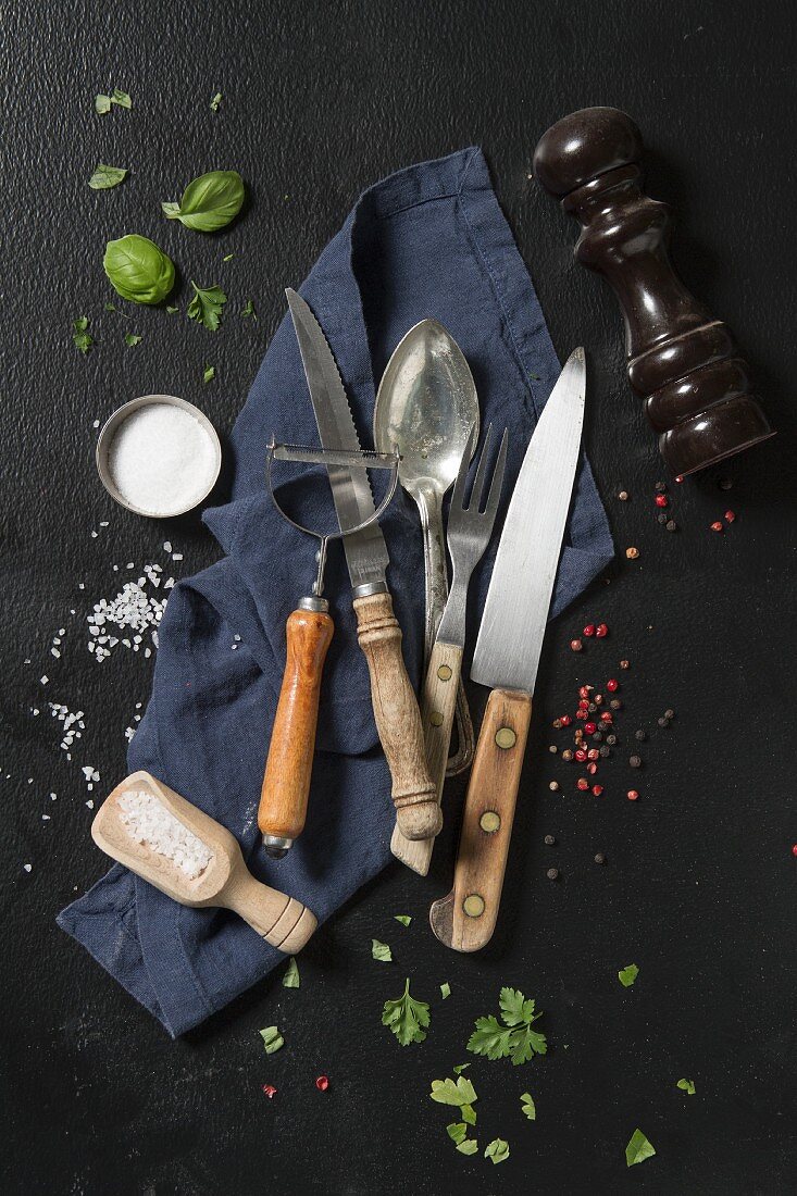 An arrangement of cutlery, a napkin, herbs and spices